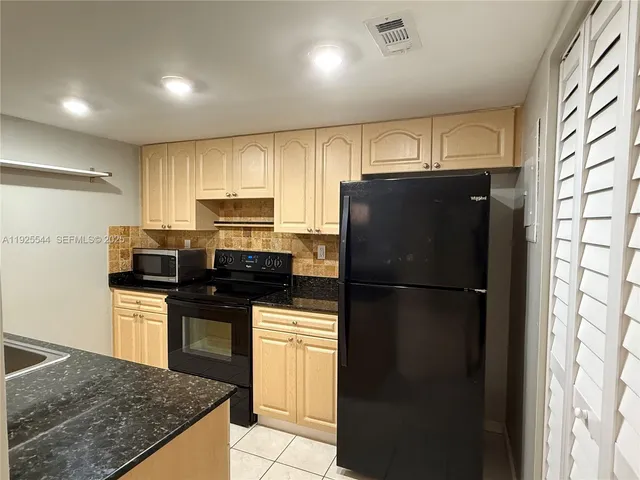 a kitchen with stainless steel appliances granite countertop a refrigerator a stove a sink dishwasher and a refrigerator