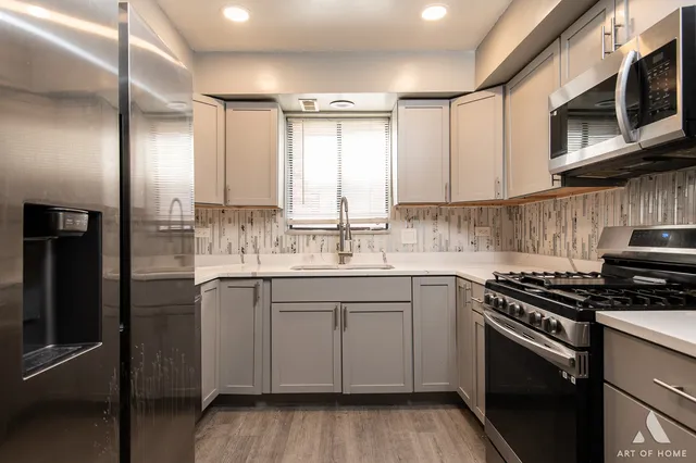 a kitchen with stainless steel appliances granite countertop a stove a sink and a microwave