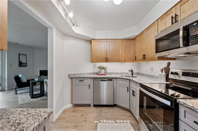 a kitchen with stainless steel appliances a sink a stove a microwave and cabinets