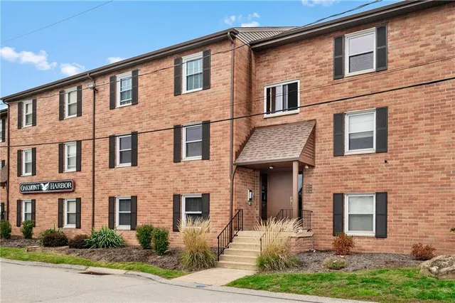 a front view of a house with yard and green space