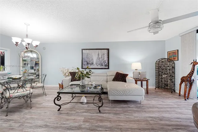 a living room with furniture a wooden floor and a lamp