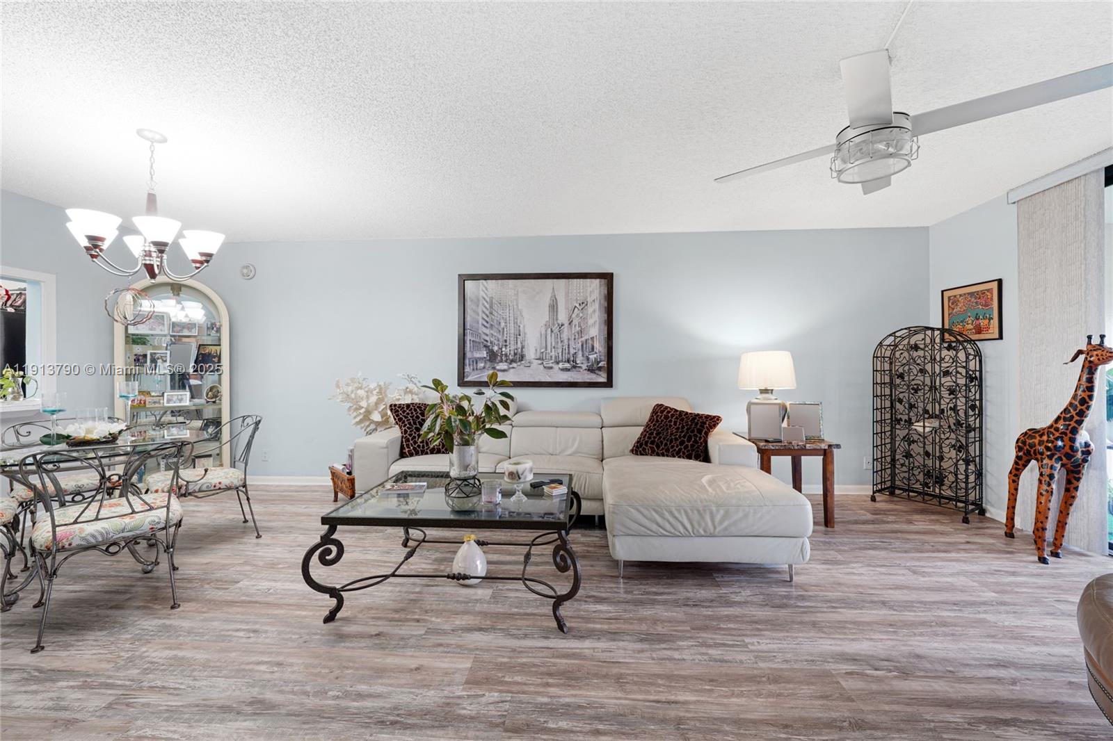 2430 DC Country Club Boulevard, Unit 6092 Deerfield Beach, FL 33442 - Photo 6 of 32 a living room with furniture a table and a chandelier