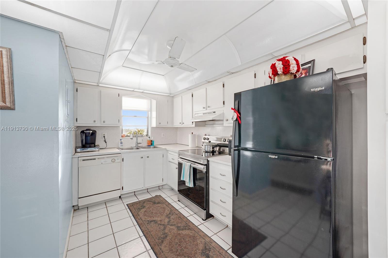 2430 DC Country Club Boulevard, Unit 6092 Deerfield Beach, FL 33442 - Photo 9 of 32 a kitchen with a refrigerator and a sink