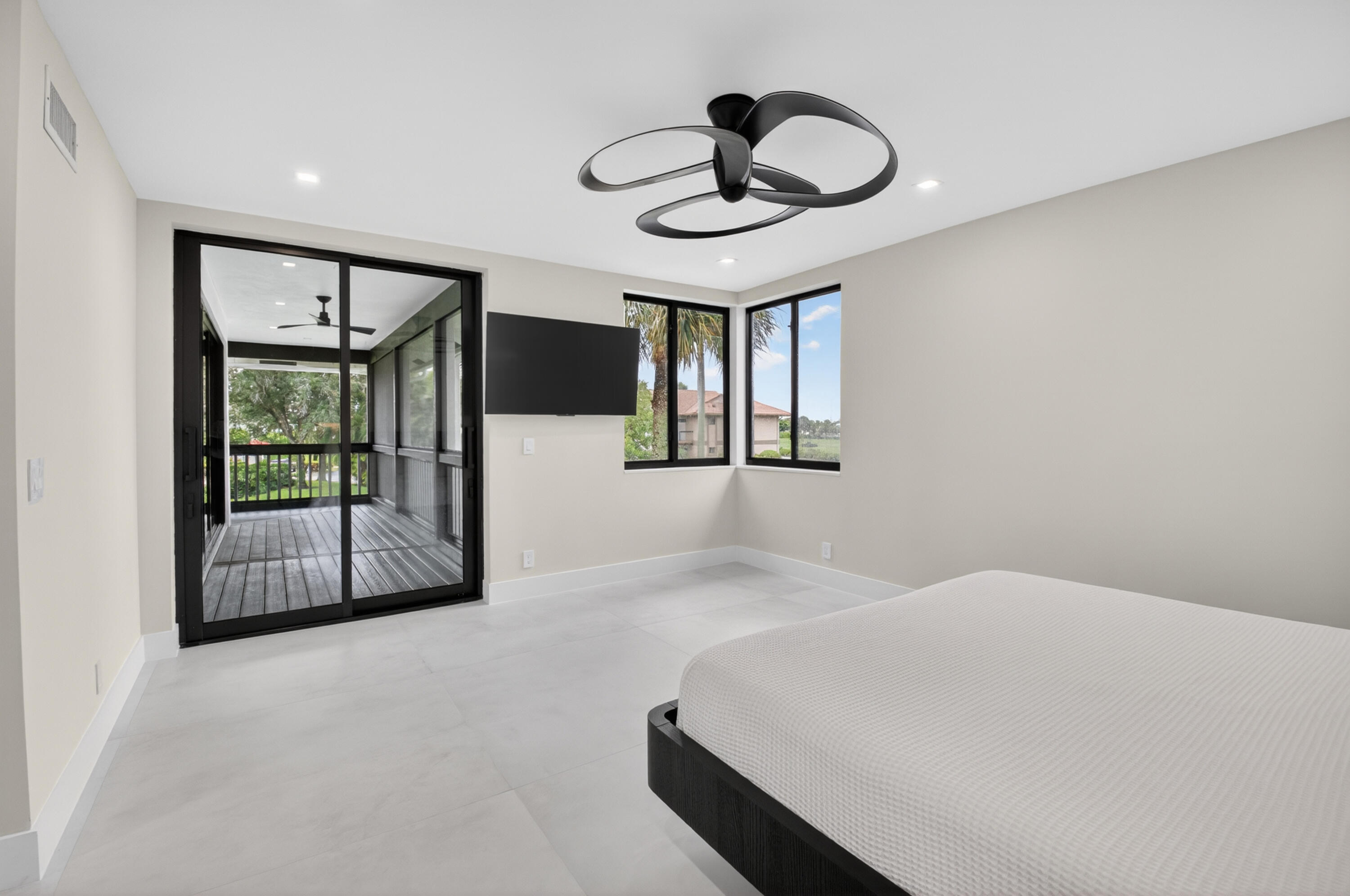 19221 Sabal Lake Drive, Unit 5124 Boca Raton, FL 33434 - Photo 30 of 98 a bedroom with a large bed and a chandelier