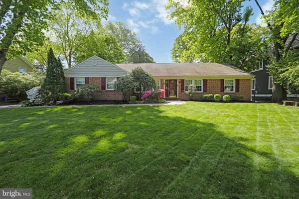 a view of a house with a big yard and large trees