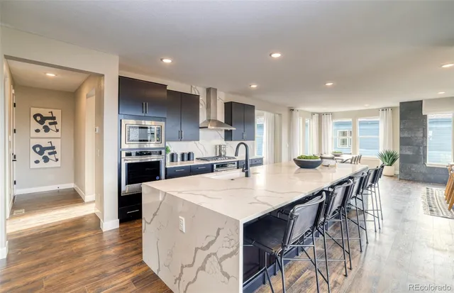 an open kitchen with kitchen island and stainless steel appliances