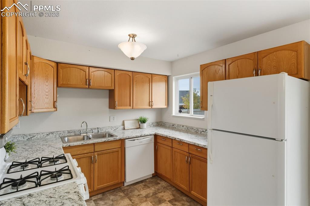 9430 Bar B Road Fountain, CO 80817 - Photo 16 of 43 a kitchen with sink a refrigerator and white cabinets