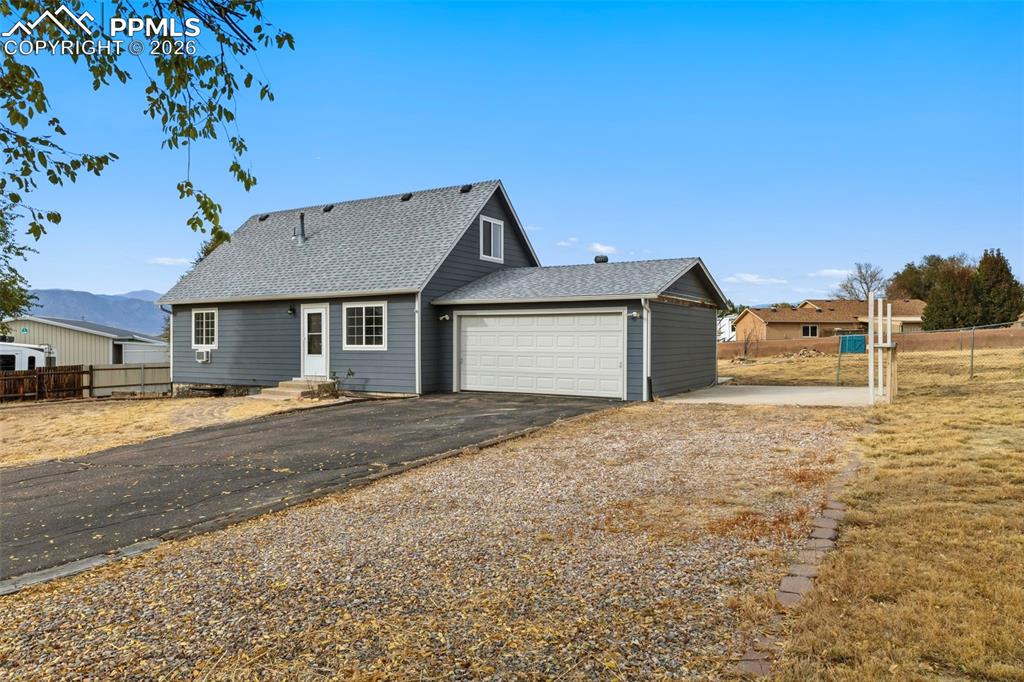 9430 Bar B Road Fountain, CO 80817 - Photo 4 of 43 a front view of a house with a yard and garage