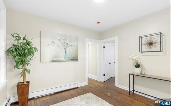a view of a hallway with wooden floor and a potted plant