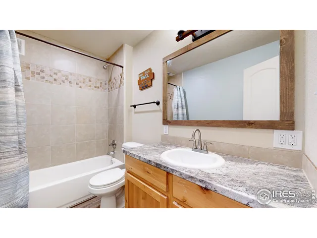 a bathroom with a granite countertop sink mirror vanity and toilet