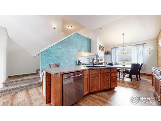 a living room with stainless steel appliances kitchen island granite countertop a sink and cabinets
