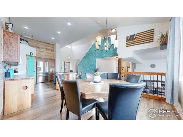 a open kitchen with stainless steel appliances kitchen island granite countertop a table chairs and a refrigerator