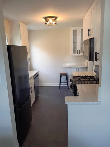 a kitchen with cabinets and a refrigerator