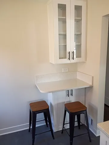 a room with table chair and windows