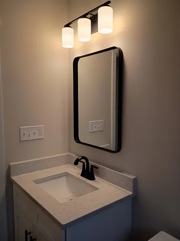 a bathroom with a sink vanity and a mirror