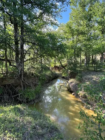 a view of a lake with lawn chairs