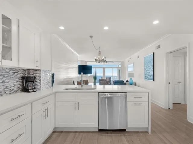 a kitchen with white cabinets appliances and sink