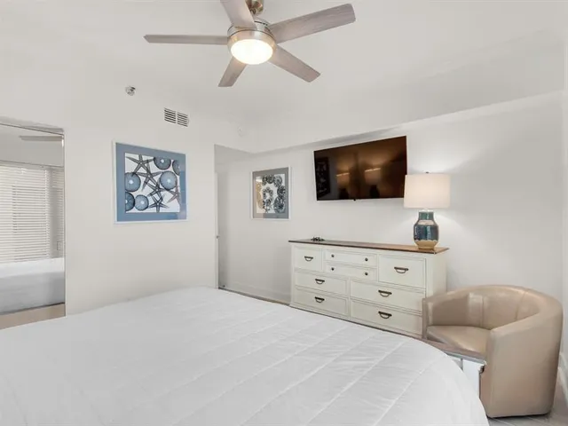 a bedroom with a bed a flat screen tv and a window