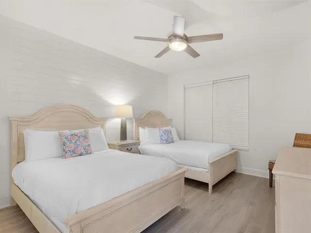 a bedroom with two bed and a chandelier