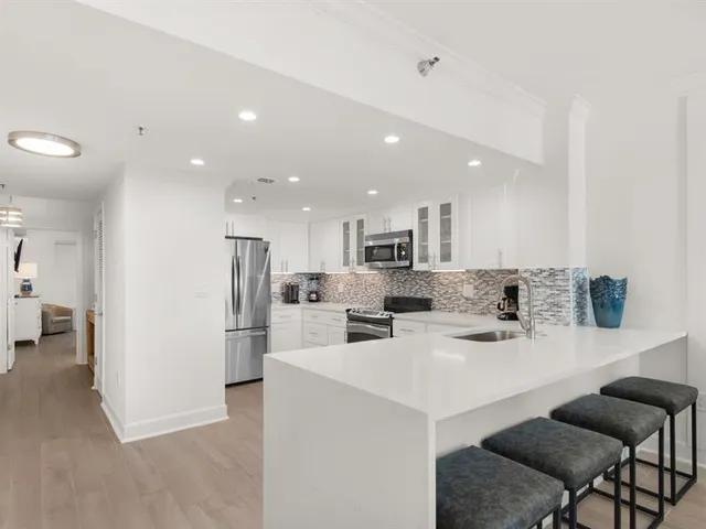 a kitchen with white cabinets and stainless steel appliances