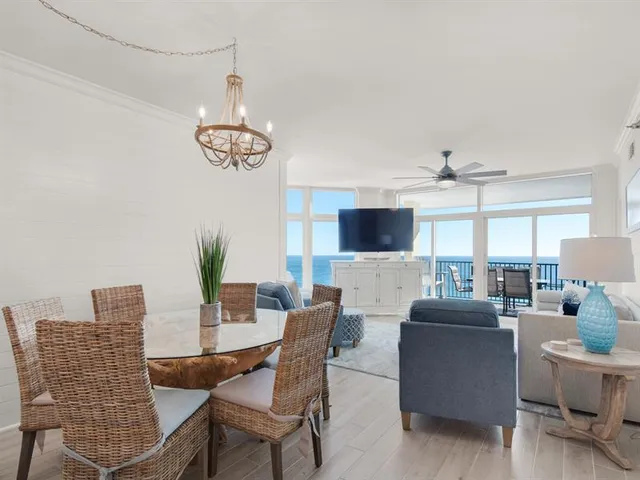 a living room with furniture kitchen view and a potted plant
