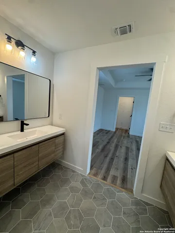 a spacious bathroom with a mirror and a sink