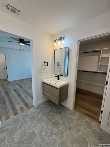 a bathroom with a double vanity sink mirror and tub