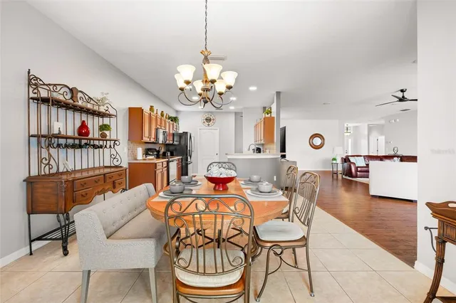 a dining room with furniture a chandelier and wooden floor