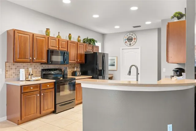 a kitchen with stainless steel appliances granite countertop a refrigerator and a stove top oven