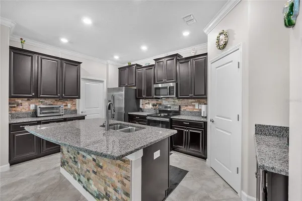 a kitchen with kitchen island granite countertop stainless steel appliances and wooden cabinets
