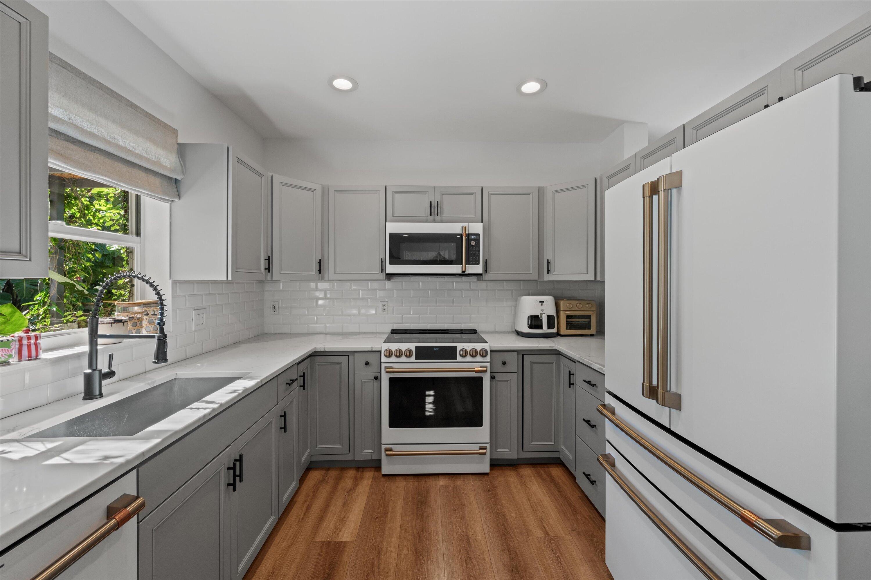 4138 Bluff Harbor Way Wellington, FL 33449 - Photo 16 of 48 a kitchen with granite countertop a sink stainless steel appliances and window