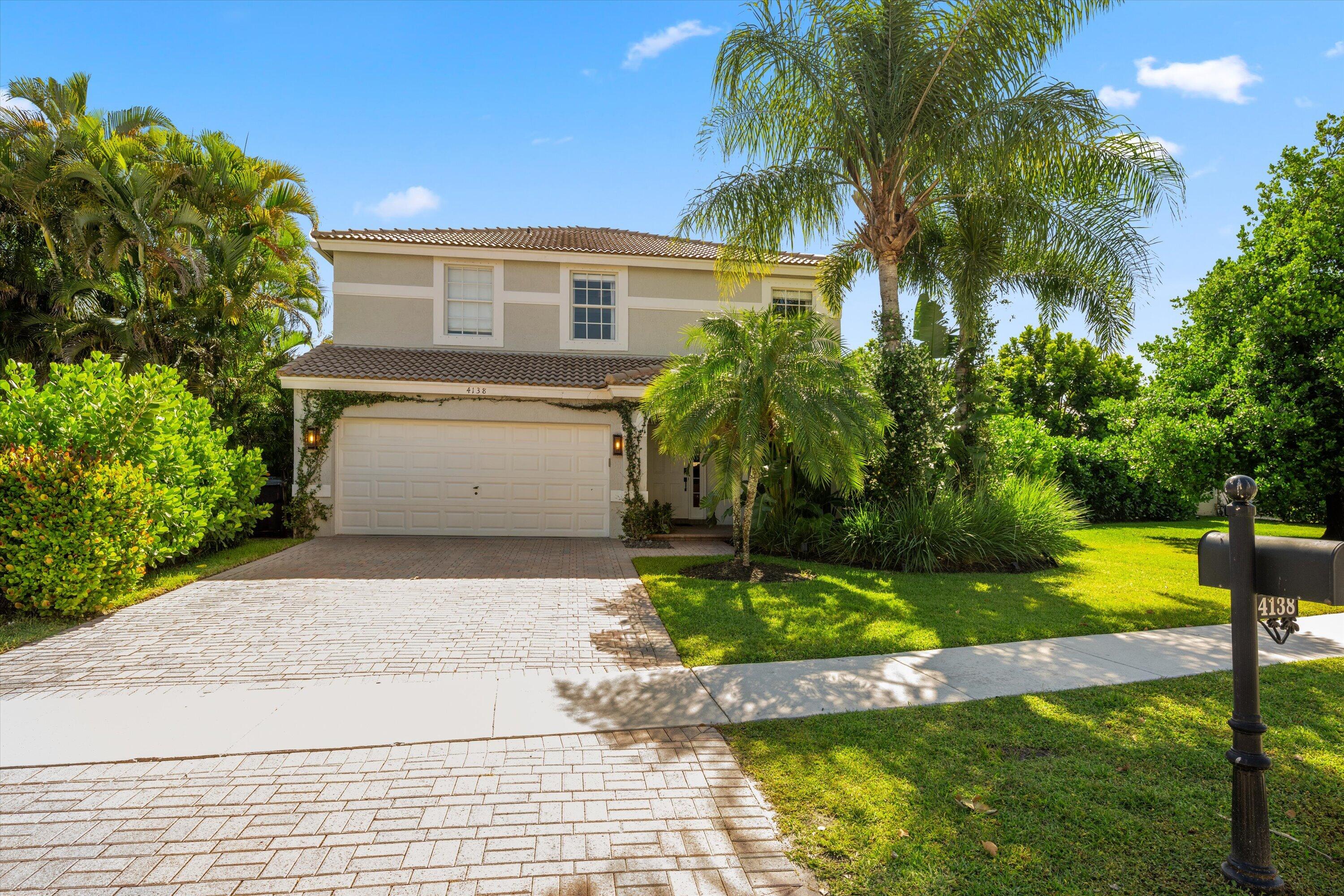 4138 Bluff Harbor Way Wellington, FL 33449 - Photo 2 of 48 a view of house with a yard and potted plants