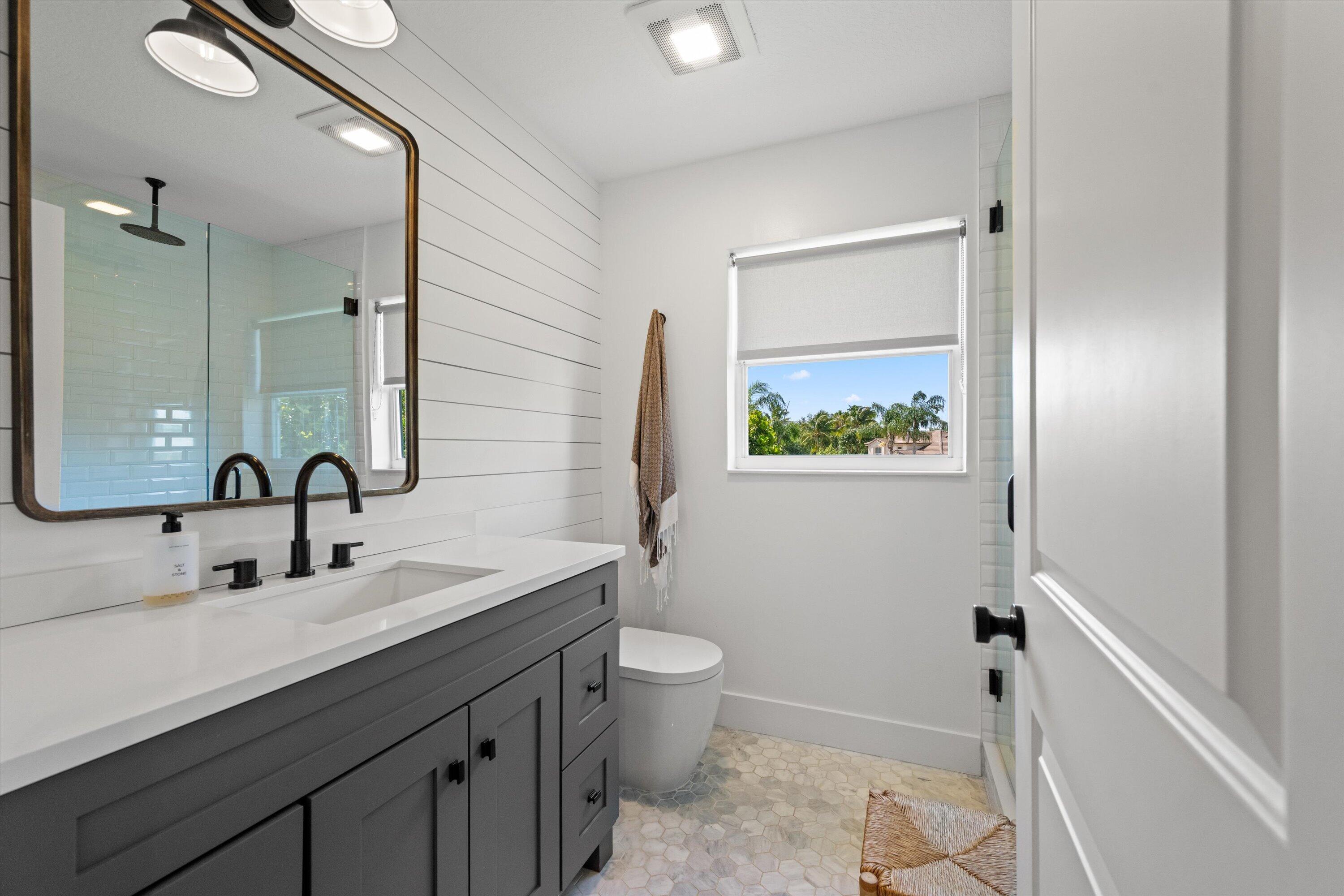 4138 Bluff Harbor Way Wellington, FL 33449 - Photo 28 of 48 a bathroom with a toilet a sink a mirror and a shower