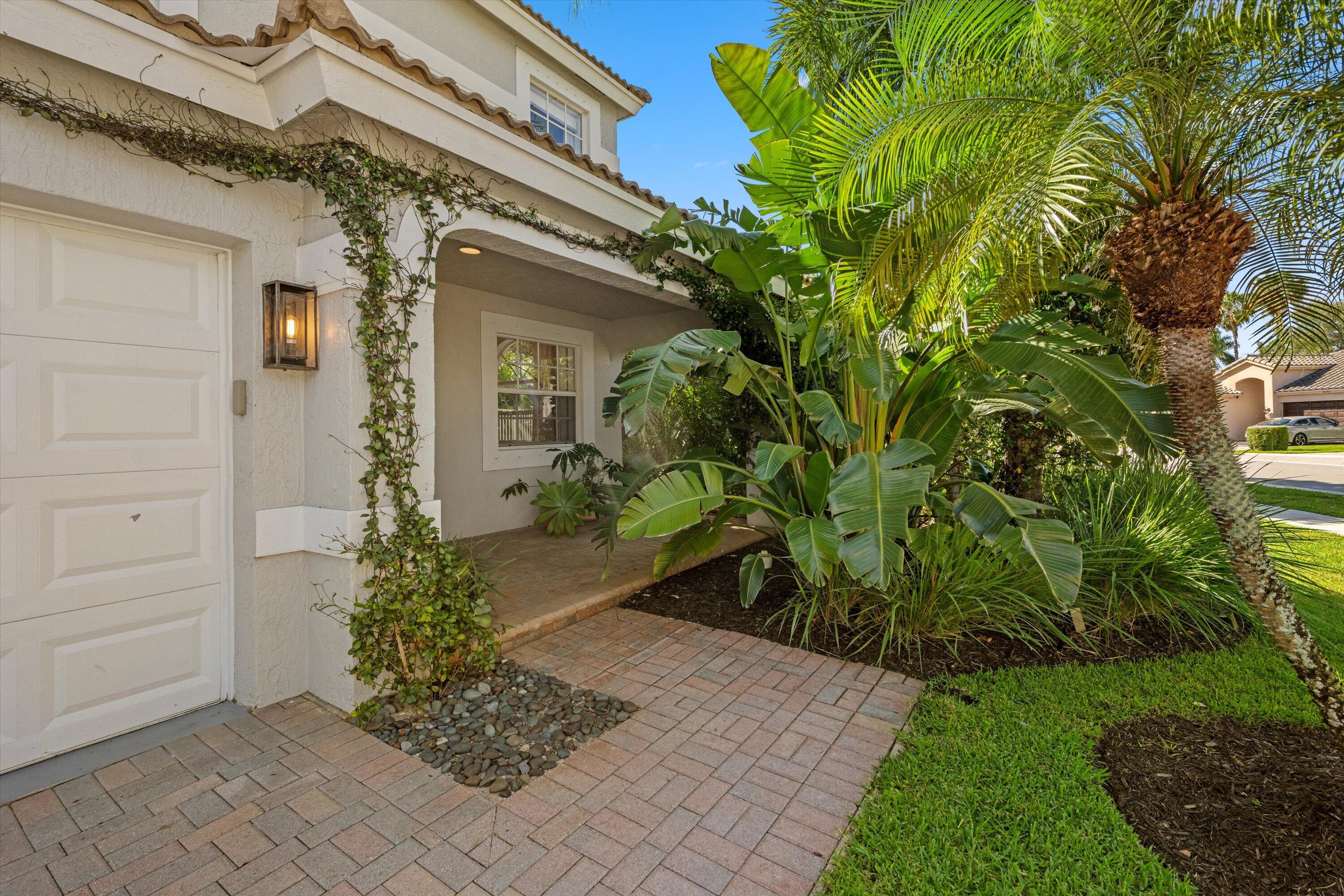4138 Bluff Harbor Way Wellington, FL 33449 - Photo 4 of 48 a front view of a house with a garden