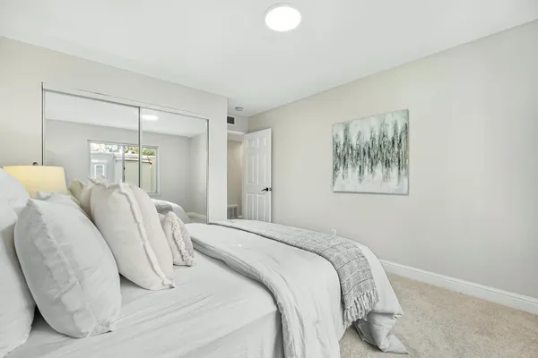 a bedroom with a bed and a painting on the wall