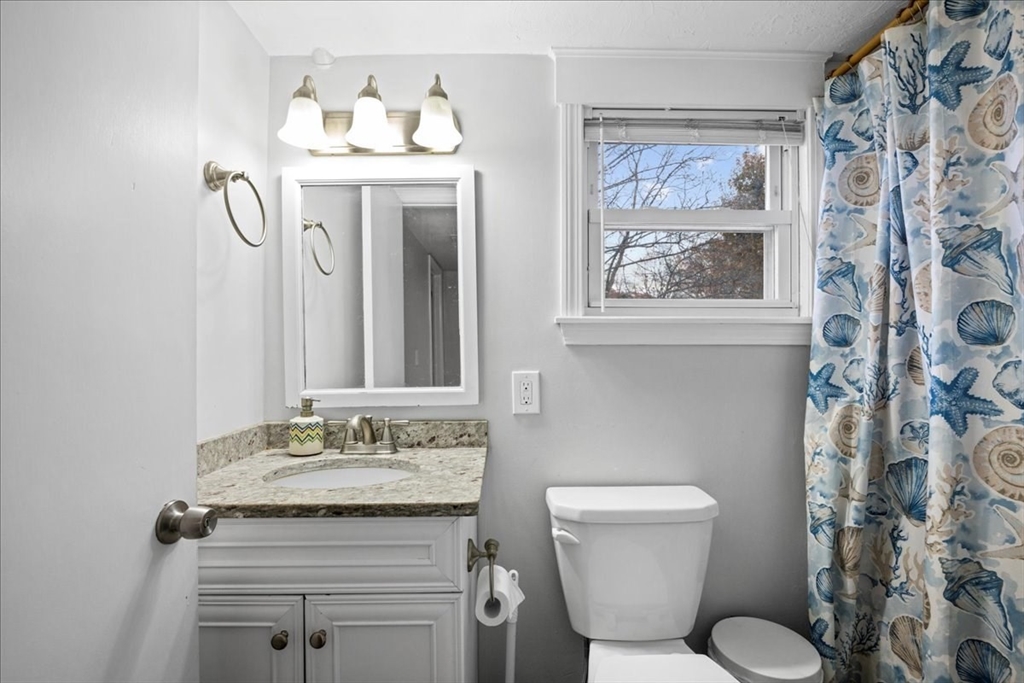65 Edgewater Avenue Shrewsbury, MA 01545 - Photo 16 of 35 a bathroom with a granite countertop sink toilet and a mirror