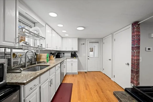 a kitchen with granite countertop a sink stainless steel appliances and cabinets