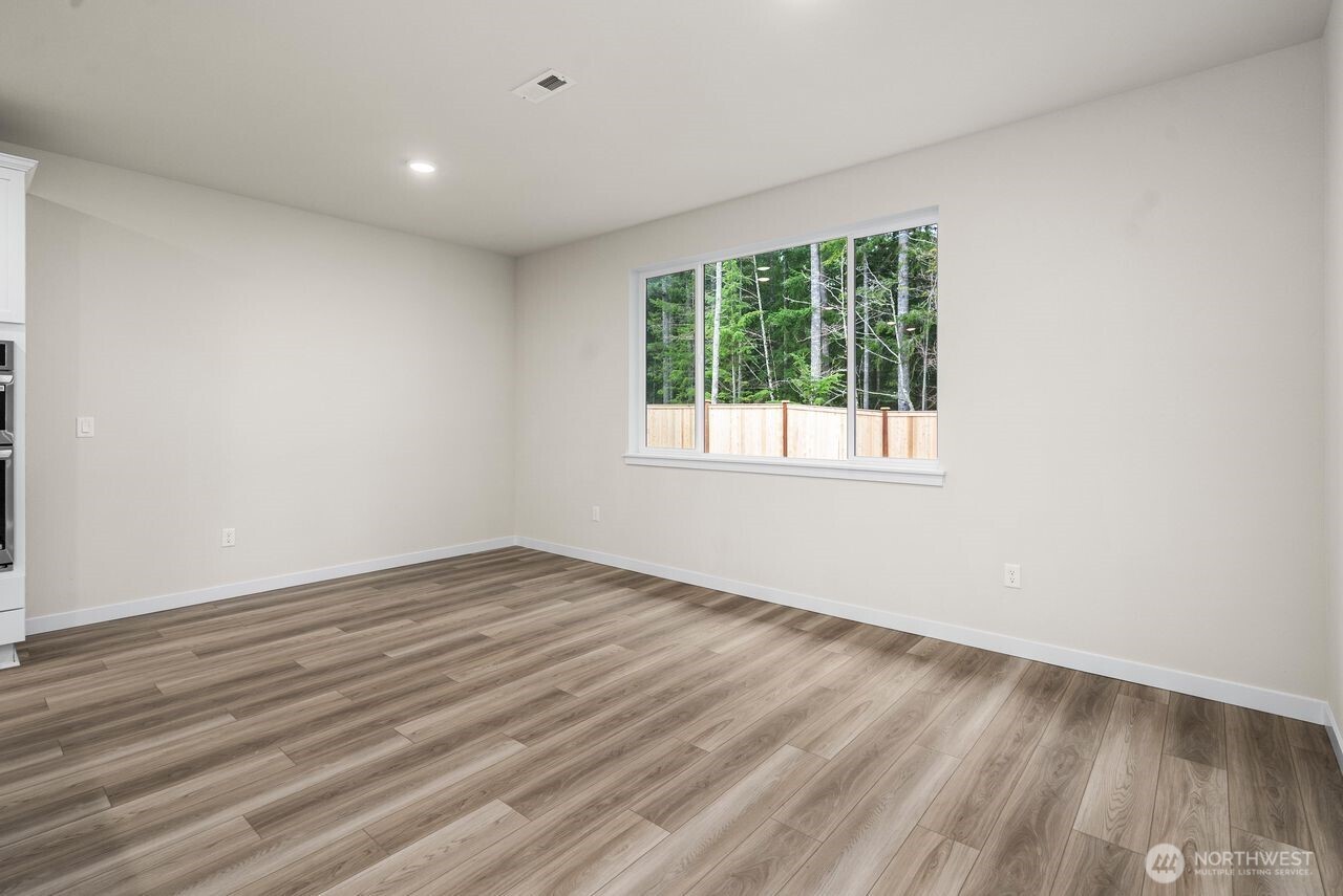 5904 Trce Drive Southwest Port Orchard, WA 98367 - Photo 22 of 29 an empty room with wooden floor and windows