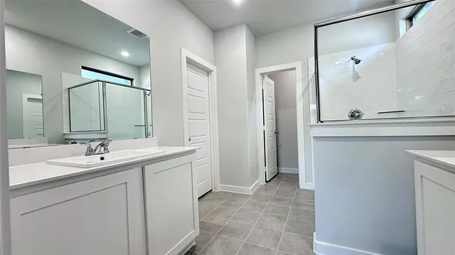 a bathroom with a sink and mirror with bathtub