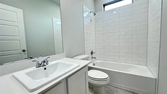 a bathroom with a bathtub shower sink vanity mirror and toilet