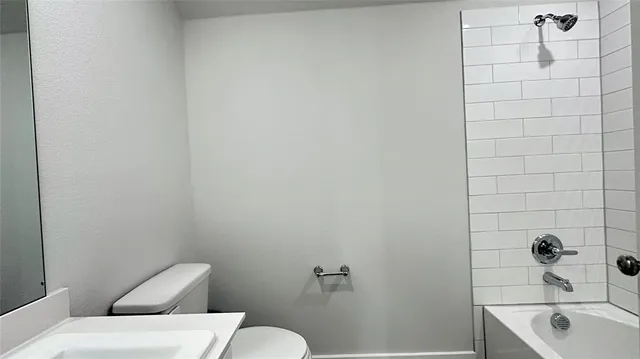 a white toilet sitting next to a bath tub
