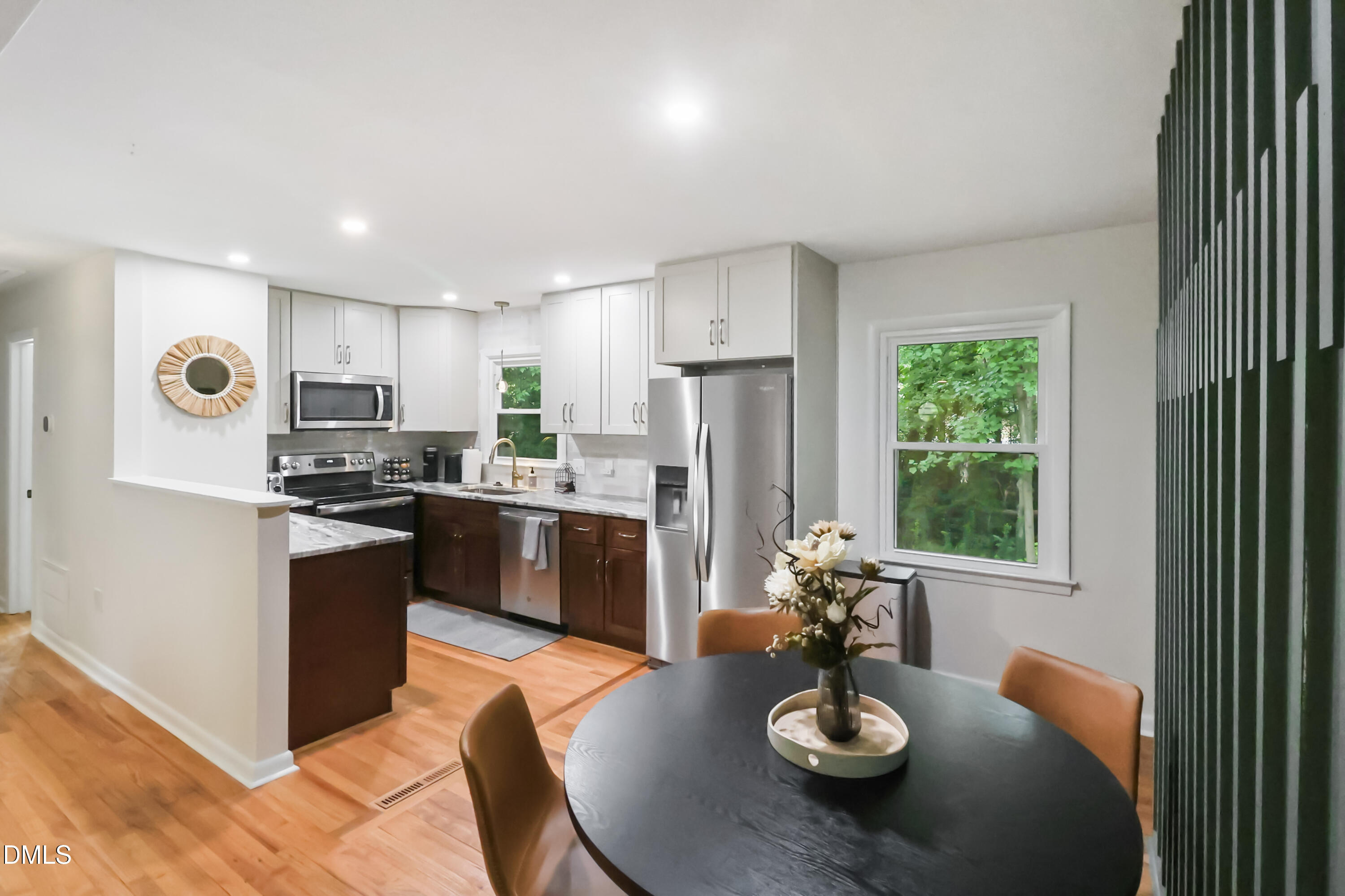 115 Bertie Drive Raleigh, NC 27610 - Photo 7 of 27 a kitchen with stainless steel appliances granite countertop a refrigerator a stove top oven a sink dishwasher and white cabinets with wooden floor