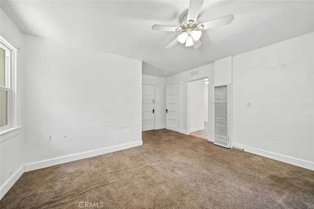 a backyard of a house with wooden fence and large trees