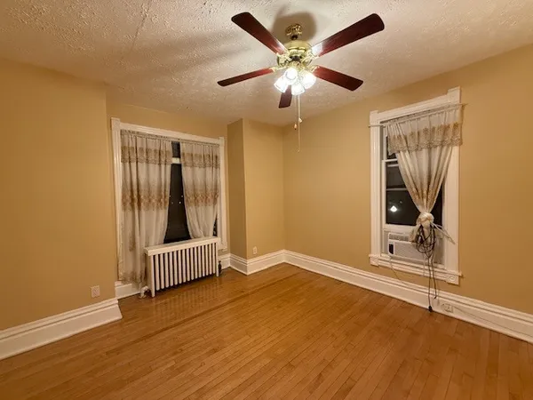 an empty room with wooden floor and white walls