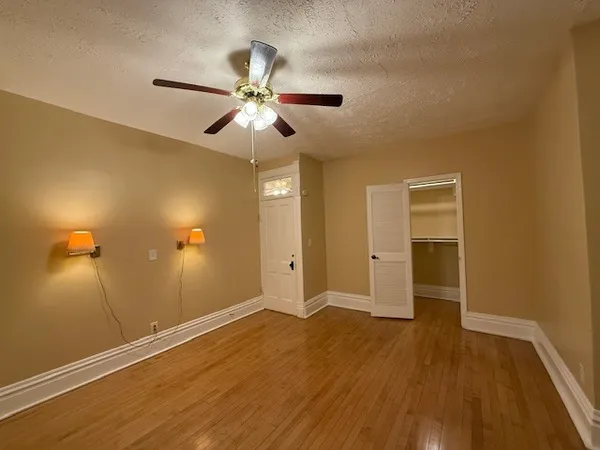 a view of room with wooden floor and ceiling fan
