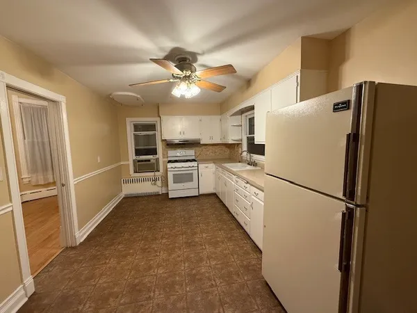 a white refrigerator freezer and a stove sitting inside of a kitchen