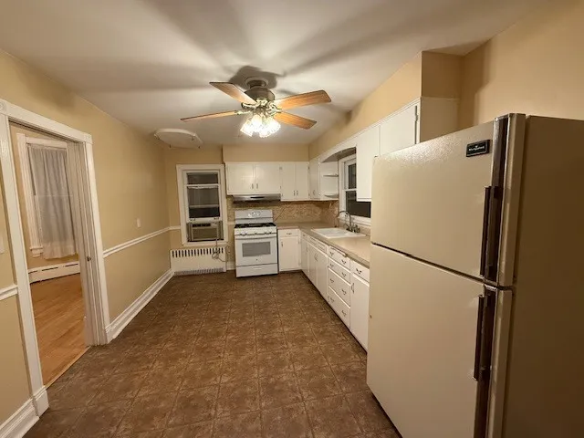 a white refrigerator freezer and a stove sitting inside of a kitchen