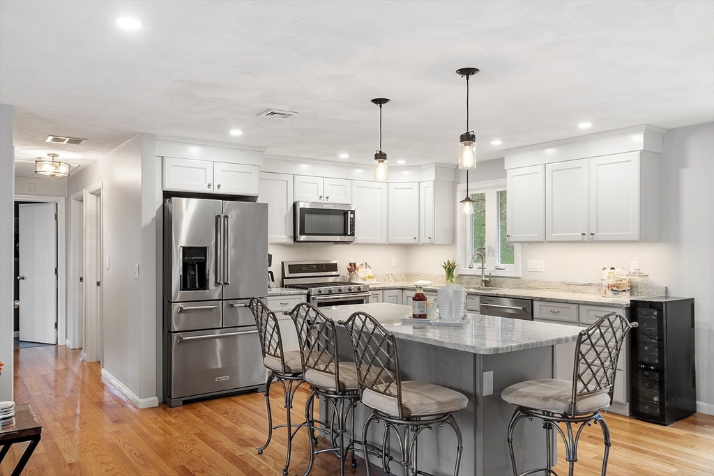 16 Michael Road Maynard, MA 01754 - Photo 4 of 39 a kitchen with stainless steel appliances a stove a sink a refrigerator a microwave oven with a dining table and chairs