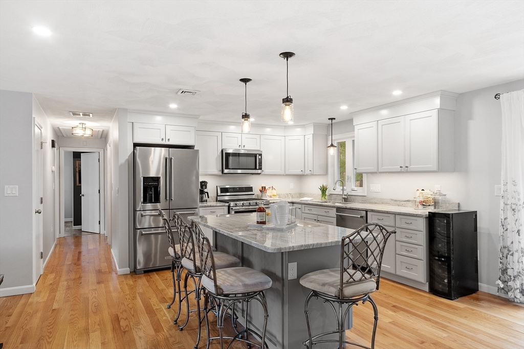 16 Michael Road Maynard, MA 01754 - Photo 5 of 39 a kitchen with stainless steel appliances a dining table chairs stove refrigerator and cabinets