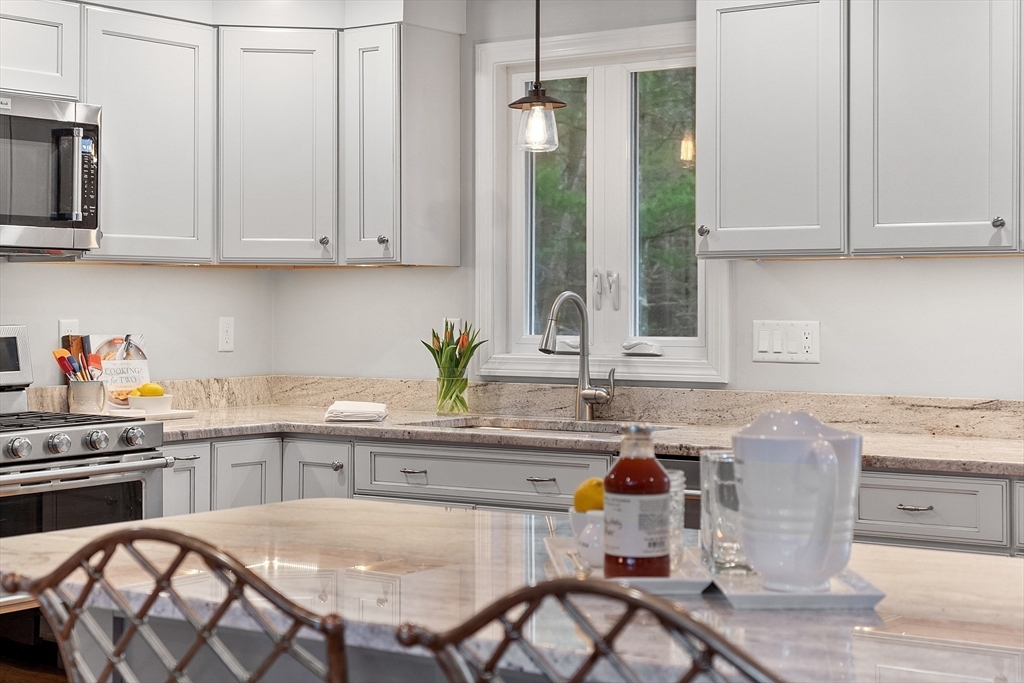16 Michael Road Maynard, MA 01754 - Photo 6 of 39 a kitchen with stainless steel appliances granite countertop a table chairs sink and cabinets